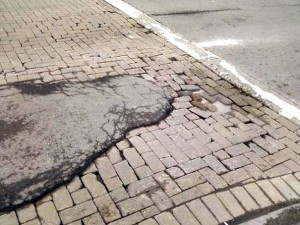 A gob of blacktop was the sloppy repair strategy for a cobblestone crosswalk at Third and Niagara. Funded by USA Niagara and the city, ten years later the collapsing cobblestone of the "Revitalization Initiative" is scandalous, stark evidence of yet another "economic development" boondoggle .