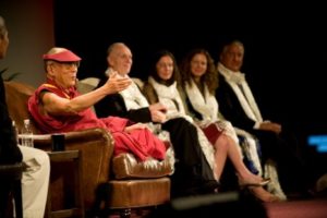 The Dalai Lama appears onstage with Clare and Sara Bronfman.